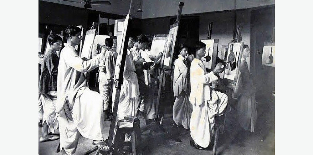 A group of male art students dressed in white dhotis and kurtas, paint a still-life scene on separate easels.