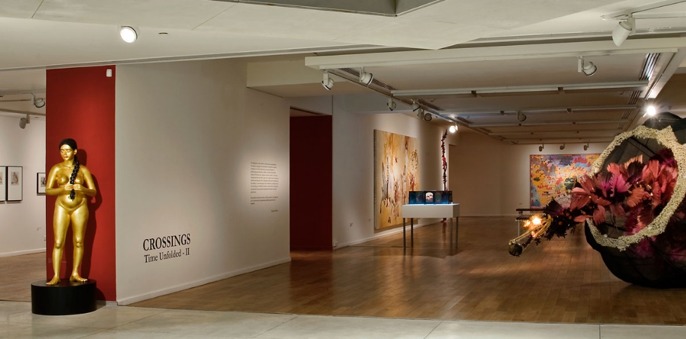 An exhibition space with large paintings, sculptures and text on the walls.